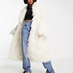 Vit lång pälsjacka - Säljer en supercool vit lång pälsjacka som verkligen gör ett statement. Den är perfekt för att hålla sig varm och stilren under kyliga dagar. Jackan har en lång och fluffig design som ger en lyxig känsla. Från weekday helt ny