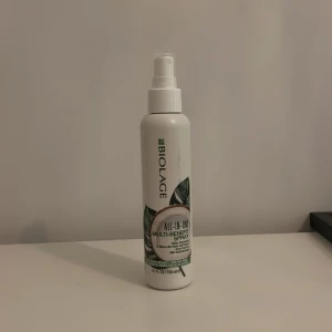 Biolage All-In-One Multi-Benefit Spray - Säljer en Biolage All-In-One Multi-Benefit Spray i en vit flaska med grön logotyp och bladmotiv. Perfekt för att ge håret extra vård och glans. Flaskan har en praktisk sprayfunktion för enkel applicering.😎😎