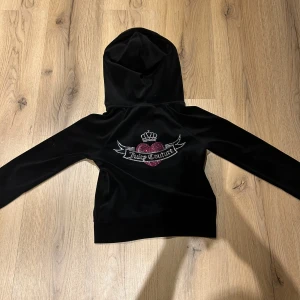  Juicy Couture kofta - ‼️{PRISET GÅR ATT DISKUTERA‼️}Säljer en superfin svart hoodie från Juicy Couture i storlek XS. Den har en glittrig Juicy Couture-logga med ett rosa hjärta och krona på ryggen,   köpte den för 1200kr för ungefär 1 år sen säljer den då jag aldrig använder kanske har använt 5-6 gånger men den e som ny priset är även högt då den är helt som ny💗