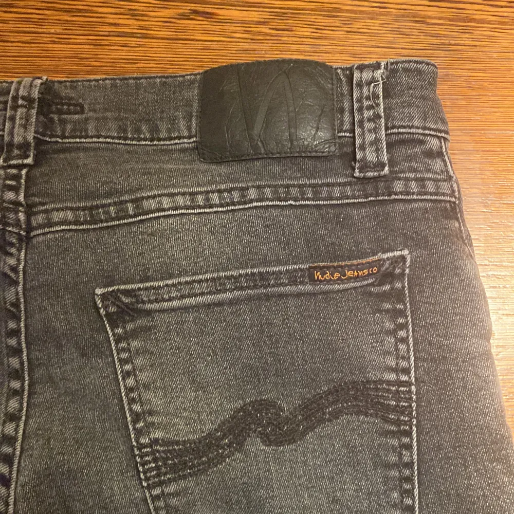 Säljer ett par mörkgråa jeans från Nudie Jeans i storlek 30/32. De är tillverkade av ekologisk bomull och har en snygg slim passform. Modellen är tight terry och sitter perfekt, skriv ang funderingar!👍. Farkut & Housut.