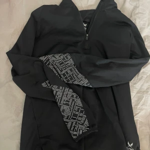 Svart sport tröja med detaljer på ärmarna. Från Soc/Stadium - Fint använda skick. St 146/152. Säljer pga inte använts. Bra passform 