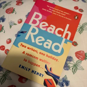 Beach Read - Säljer boken 'Beach Read' av Emily Henry. den handlar om två författare, en semester och en romcom som väntar på att hända.