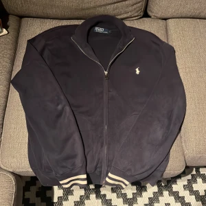 Hel zip Ralph Lauren - Säljer en snygg mörkblå tröja från Polo Ralph Lauren i storlek L, men sitter som M💙 Skicket är 8/10👕 Passar både till vardags och lite finare tillfällen nu på höst/vintern🍁Jag är 183 och tycker den är lite kort👍