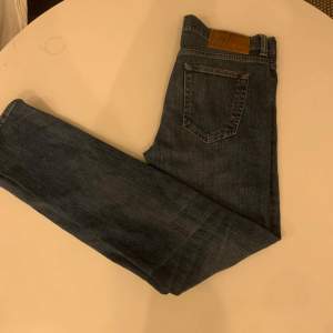 Säljer ett par snygga blå Edwin jeans, modell ED-80. De har en slim tapered passform som sitter perfekt. Klassisk femficksdesign med en läderpatch på baksidan. Perfekta för både vardag och fest!