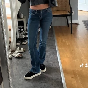 Blå jeansbyxor - Snygga lågmidjade blå jeansbyxor i bootcut-stil. Perfekta för en casual look, de är både bekväma och stilrena. Passar bra till både vardag och fest. Kombinera med en skinnjacka eller jeansjacka för en komplett outfit.