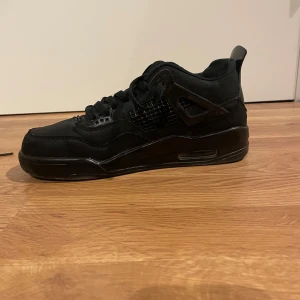 Svarta sneakers Jordan 4  - Säljer ett par svarta sneakers i mycket bra skick. De har en stilren design med snörning och en bekväm passform. Perfekta för både vardag och festliga tillfällen. Skorna är i storlek herr 39 och passar en storlek 40. 