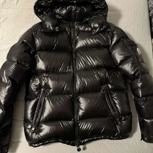  Moncler Maya - Säljer en snygg svart dunjacka från Moncler i mycket bra skick. Den är helt ny och är 10/10 skick. Jackan har inga defekter och är helt stilren, den är i storlek (S). Jag säljer jackan för 2100