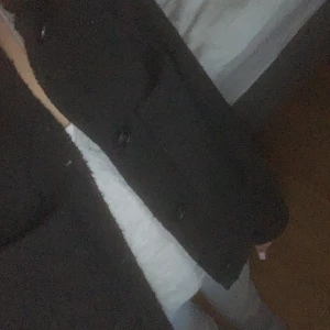 Svart kavaj med knappar - Säljer en klassisk svart kavaj med knappar framtill. Den har en klassisk passform och är långärmad. Passar bra till höst och vår. Ett måste i garderoben för en chic look!