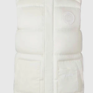 Vit dunväst från Canada Goose - Säljer en snygg vit dunväst från Canada Goose i mycket bra skick. Västen har en dragkedja framtill och två praktiska fickor. Perfekt för kyliga dagar när du vill hålla dig varm och stilren. Passar till både vardag och fest!