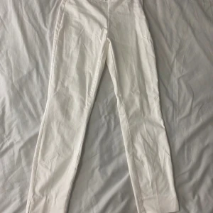 Vita byxor - Säljer ett par vita byxor i bra skick. De har en straight passform och är perfekta för både vardag och fest. Byxorna är tillverkade i ett mjukt och bekvämt material, vilket gör dem sköna att bära hela dagen. Perfekta för vår och sommar!