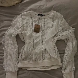 Vit spetsblus från guess - Säljer en superfin vit blus från Soyaconcept i nytt skick. Den har långa ärmar och är täckt med vacker spets och volanger. Perfekt för vår och sommar, och funkar både till vardags och fest. Storlek S. 🌸