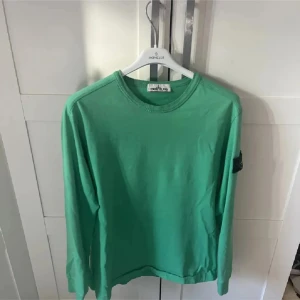 Grön långärmad tröja från Stone Island - Säljer en snygg grön långärmad tröja från Stone Island. Perfekt för både vardag och lite mer avslappnade tillfällen. Tröjan är i princip i nyskick och har en klassisk rund halsringning. Säljer då den inte kommer till användning! (Pris går att diskuteras)