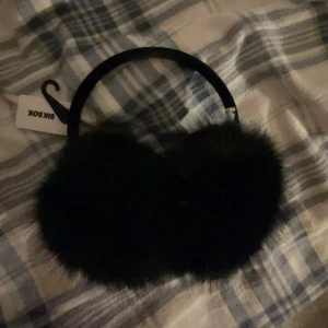 Svart öronvärmare - Fina äronvärmare med fluffiga pälsdetaljer. Perfekt för att hålla dina öron varma en kall dag.🤗Ny pris 199 och står på lappen.
