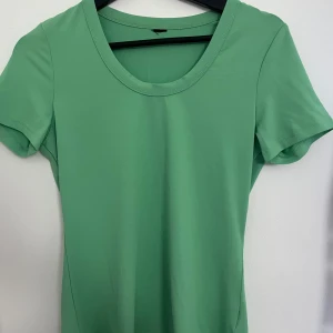 Tight grön t-shirt - Säljer denna gröna T-shirt som sitter tight på. Den är inte i bomull utan mer luftig och tunn. Använt en gång. 