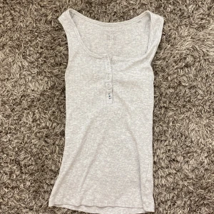 Grå topp med knappar - Grå topp med knappar