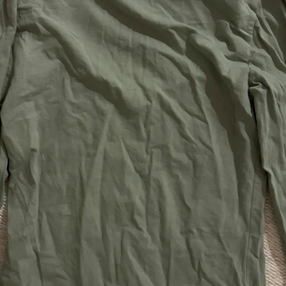 Säljer en stilren grön långärmad topp med rund halsringning. Perfekt för en avslappnad look. Passar bra till jeans eller kjol.. Yläosat.