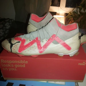 Puma Future Ultimate - Snygga fotbollsskor från Puma i beige och röd med snörning och en modern design. Perfekta för fotbollsplanen med bra grepp och stil.