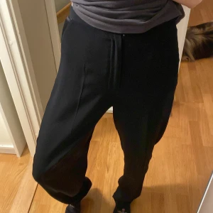 Svarta kostymbyxor  - Ett par lösa svarta kostymbyxor med fin sidenremsa på sidorna. Högmidjade med långa ben. Verkligen supersköna! Väl omhändertagna 🤍