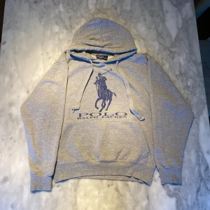 Grå ralph Lauren hoodie  - Skick: 8/10. Tröjan har ingen storleksetikett men har måtten av en small. Kan bifoga mått vid önskan! Har du några andra frågor är det bara att höra av sig.