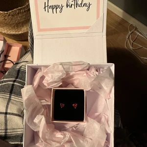 örhängen och halsband från Pandora - Säljer ett set med hjärtformade örhängen och ett matchande armband från Pandora. Min kille gjorde slut med mig och vill ha bort det så fort som möjligt. Båda smyckena har en vacker röd sten i hjärtform och är perfekta för att ge en romantisk touch till din stil. Kommer i originalförpackning med presentkvitto och äkthetsbevid. Går att köpa separat: halsband för 750kr och örhängen för 650kr