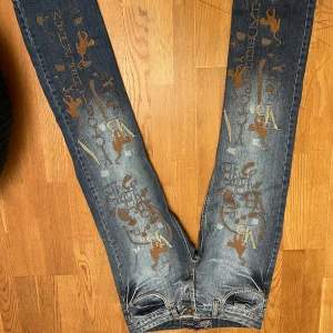 Jeans från Victoria Beckham för Rock & Republic - Oanvända och sällsynta jeans med coola tryck i brunt och blått. Designade av Victoria Beckham för Rock & Republic. Perfekta för dig som vill sticka ut med stil. Storlek S men lite långa så skulle nog passa någon längre. Pris kan diskuteras. Hör av dig om du vill ha mått eller fler bilder!