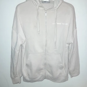 Beige hoodie från FB Sister - Säljer en beige hoodie från FB Sister i storlek XXS. Den har dragkedja framtill och en justerbar huva med snören. Perfekt för en avslappnad stil.