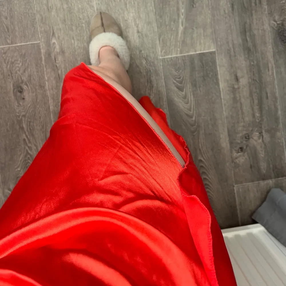 Snygg röd oneshoulder klänning med slits och dragkedja. Satintyg och blänkande röd/orange/rosa färg, perfekt till tex bal! Oanvänd då den är för kort för mig som är ca 165💕. Mekot.