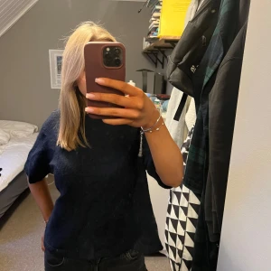 Mörkblå kortärmad tröja - Säljer en stilren mörkblå tröja med korta ärmar. Det är dn stickad T-shirt från Gina Tricot som köptes förra året men som knappt kommit till användning och som därav är i väldigt bra skick! Köptes för 299kr!