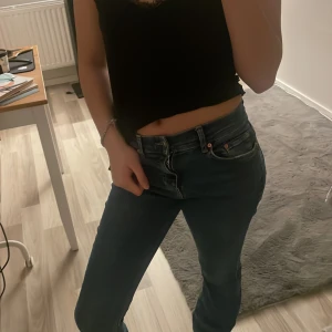 Mörk Blå jeans med normal passform - Snygga blå jeans med normal passform och klassisk design. De har en knappgylf och femficksmodell, vilket ger en tidlös look. Perfekta för en avslappnad stil. 