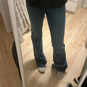 Blå jeans från H&M Divided - Snygga blå jeans från H&M Divided med en klassisk design. De har en rak/utsvängd passform och är perfekta för en avslappnad stil. Jeansen har en knapp och dragkedja framtill💗