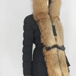 Svart dunjacka med pälsdetaljer - Snygg svart dunjacka med stor, fluffig päls runt huvan. Jackan har ett bälte i midjan för en figursydd look och långa ärmar. Perfekt för kalla vinterdagar.