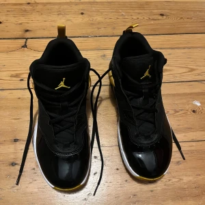 Svarta och gula Nike Air Jordans - Snygga svarta Nike Air Jordans med gula detaljer och vit sula. Skorna har snörning och en stilren design med den klassiska Jumpman-loggan. Perfekta för dig som vill ha en sportig och trendig look.