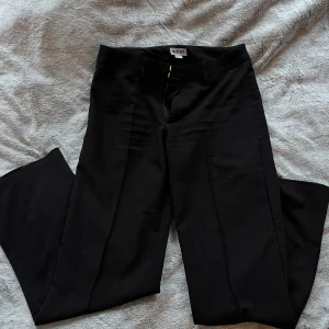 Svarta kostymbyxor från Madlady - Snygga svarta kostymbyxor från Madlady med låg midja utan fickor. Byxorna har en rak passform och är perfekta för en stilren look. De har en dragkedja framtill och är tillverkade i ett bekvämt material🖤