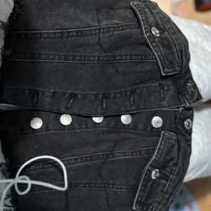 Svarta jeans topp med knappar från FB Sister/New Yorker  - Snygg svart jeans topp från FB Sister med flera knappar framtill och fickor med knappar. Perfekta för en cool och avslappnad stil.