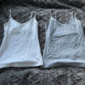 2 linnen - Två enkla linnen i vitt och grått. De har smala axelband och en v-ringad design. Båda är i storlek S och i väldigt bra skick🤗 Båda för 80kr