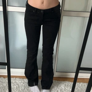 Lågmidjade Bootcut jeans lee  - Svarta Lågmidjade jeans från lee, står ingen storlek men skulle säga w28/s även väldigt stretchiga. Midjemått:38 stretch till 42. Innerbenslängd: 75. Köp sker via köp nu, jag postar inom 24h. Kvar tills markerad såld 