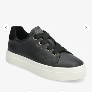 GANT Avona sneakers - Nästintill nya sneakers från GANT, jättefint skick då de knappt är använda. Köpt för 1699:-  Svarta med gulddetaljer 