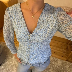 Långärmad blus - Supersöt ljusblå blommig blus som går in supersnygg i midjan! Pris kan diskuteras!😊😊