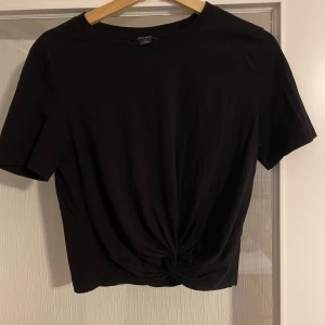 Svart t-shirt med knut - En svart t-shirt med en knut. Använd ett par gånger men är i väldigt bra skick.