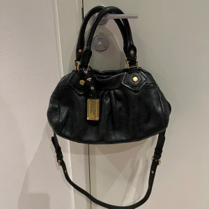 Marc Jacobs väska  - Helt ny Marc Jacobs väska i mini modell. Väskan har inga större defekter, en metal bit på vänstra sidan i handtaget gick av men inget som påverkar användningen. Jätte fin och väldigt populär verkligen 🩷Inne i väskan finns serienummer inuti väskan