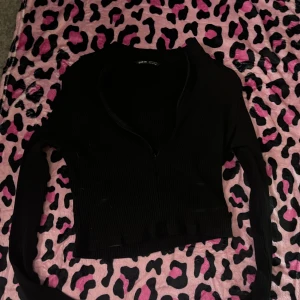 Topp - Den har dragkedja vid urringningen 