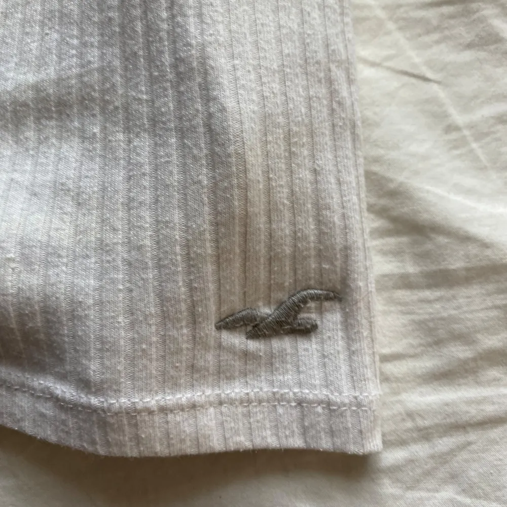 Gulligt linne från Hollister. Detalj vid brösten och märke längst ner på tröjan. Luftig och bra basic . Toppar.