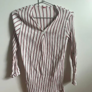 Randig blus - Randig blus med brosch. Märke & strl är okänt för att lappen var bortklippt när jag köpte den på stadsmissionens second hand. Men passar S/M. Tvättad, men ej använd.