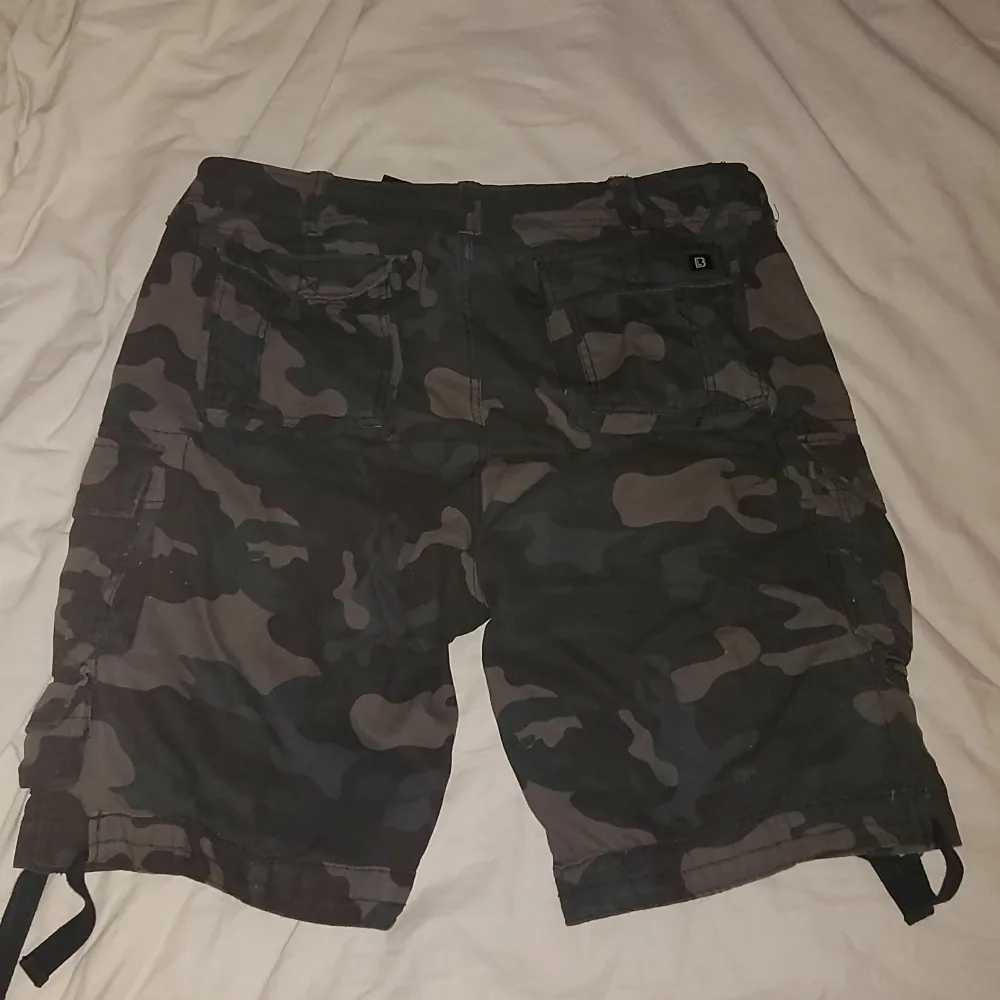 camouflage shorts från märket brandit, köpta på Blue Fox. Använda fåtal gånger och de är fortfarande i Mycket bra skick, (strl XXL men passar mig som oftast har M) bältet ingår - orginal pris typ 700kr, pris går att diskutera. Shorts.