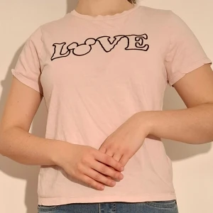 Rosa t-shirt med disney motiv - Rosa tröja med texten "LOVE" där "O" är Musse pigg motiv.  (Sista bilden visar tröjans motiv)