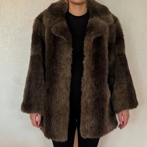 Fuskpäls  - Brun fuskpäls stor och fluffig passar storlek M  Personen på bilden är 170 cm