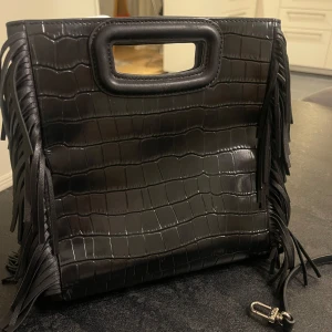 Maje väska  - Intressekoll! Denna Maje-väska köptes för nästan ett år sedan och är i superfint skick, knappt använd. Inga defekter, men det finns ett litet märke vid handtaget som knappt syns. Det påverkar absolut inte helhetsintrycket! 💓💓 