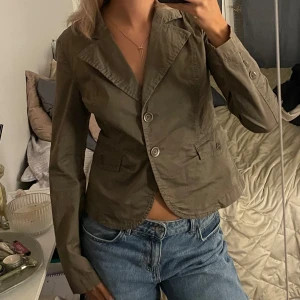 Grön jacka - Mörkgrön jacka i fint skick med knappar och fickor. Står inte storlek men skulle uppskatta s.