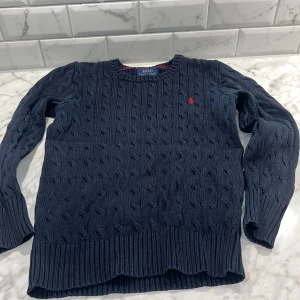 Stickad Ralph Lauren tröja - Säljer denna stickade Ralph lauren tröja, den är i mycket bra skick med inga skador, säljer den för att den har blivit för liten. Tröjan är i storlek 10-12 år. Pris kan diskuteras