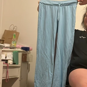 Ljusblå mjukisbyxor med snörning - Säljer ett par bekväma ljusblå mjukisbyxor med snörning i midjan. Perfekta för en avslappnad dag hemma eller på språng. Byxorna har en loose passform och är tillverkade i ett mjukt material.